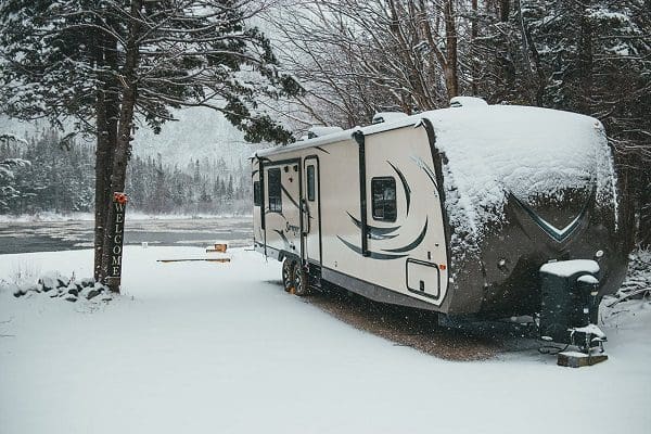 RV parked by snowy lake