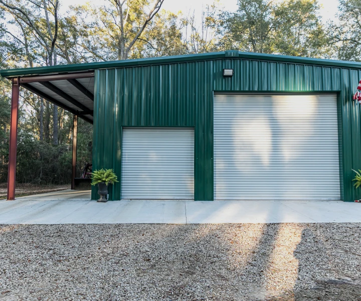 Green metal building with roller doors