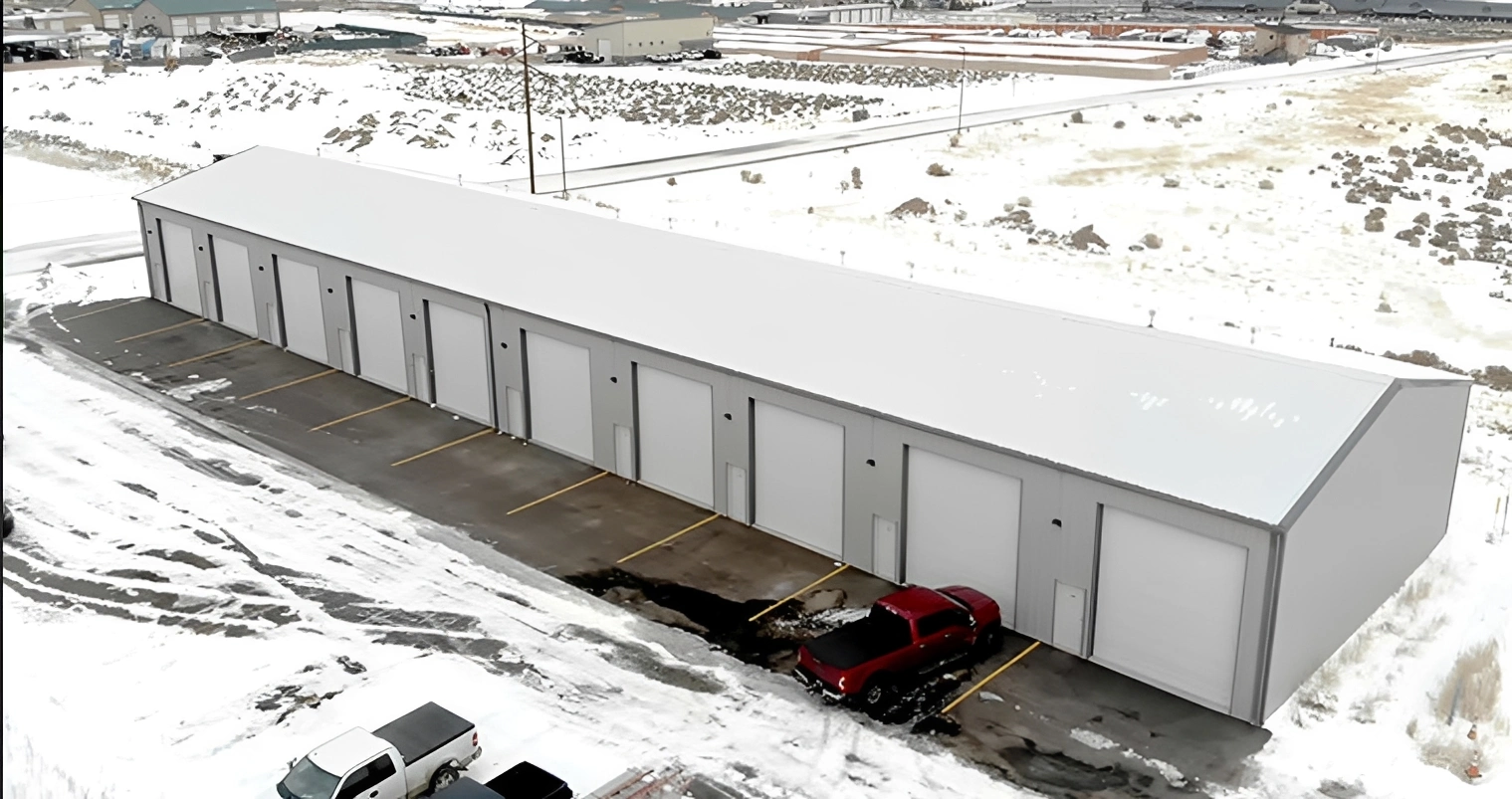 Red truck parked by warehouse in snow