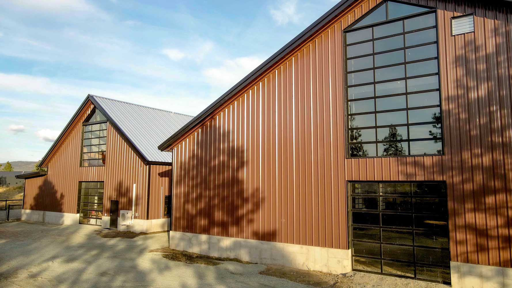 Modern metal barn buildings with large windows.