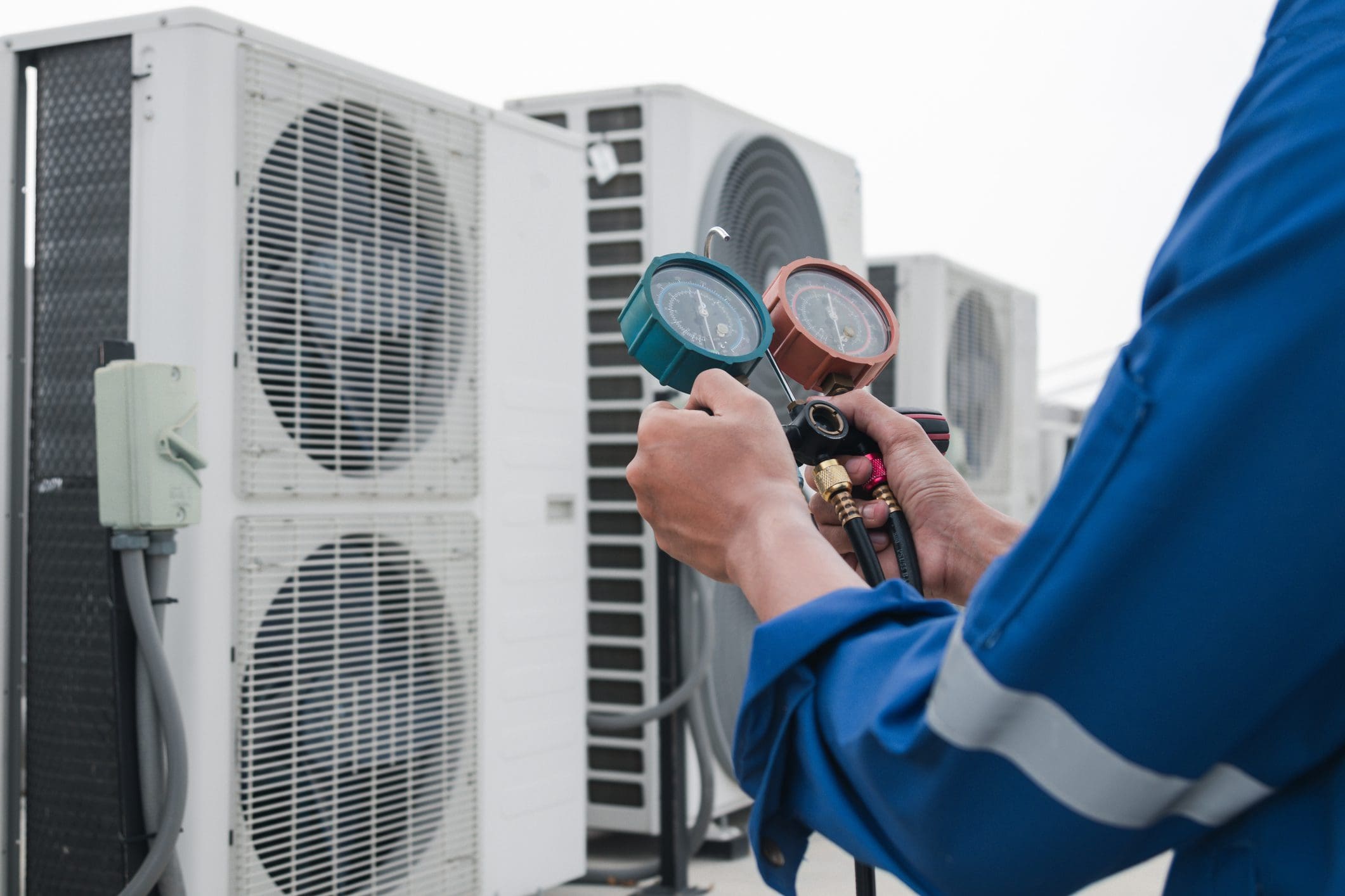 Technician checking air conditioning units gauges.