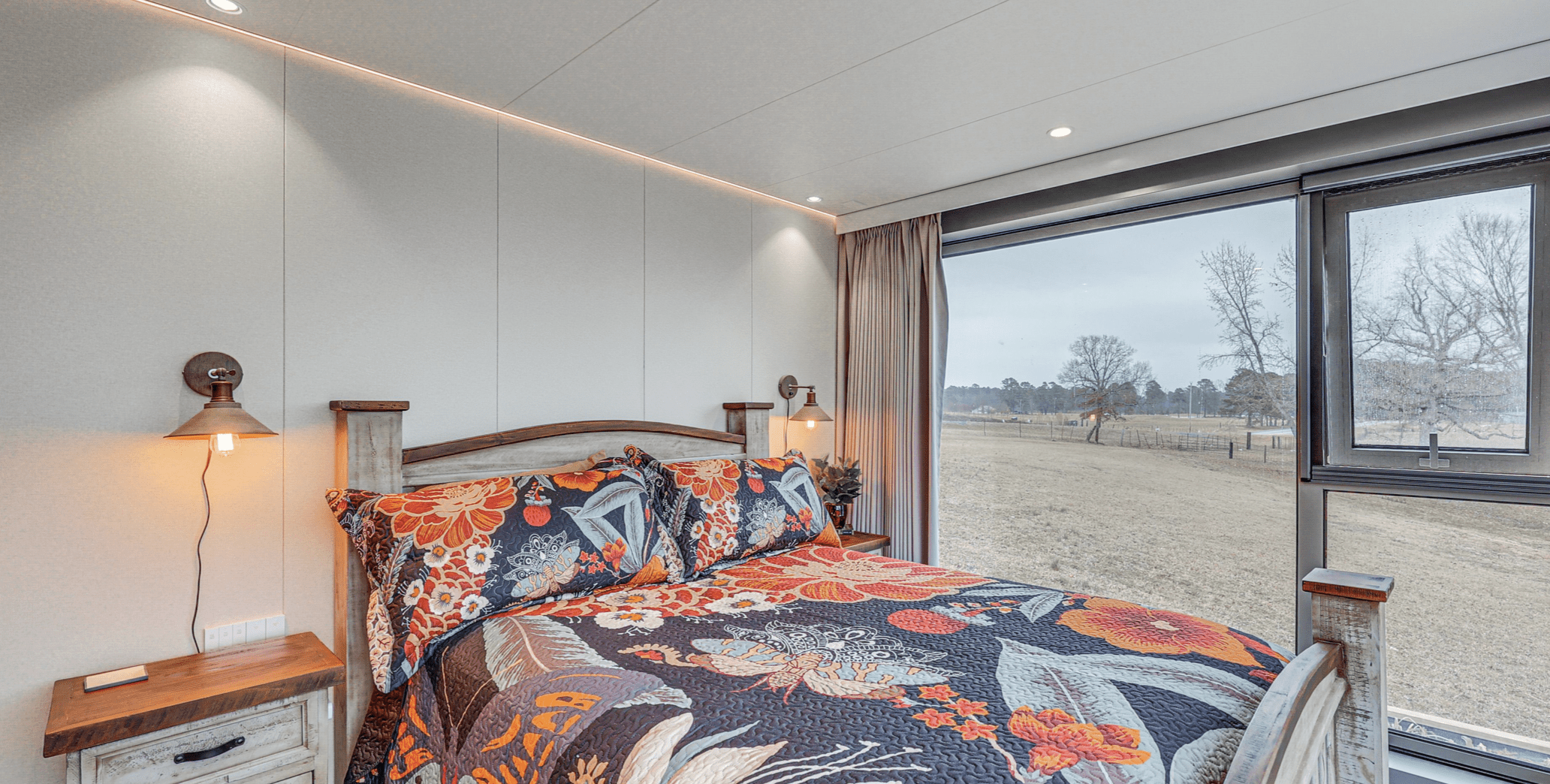 Cozy bedroom with floral bedding and view.
