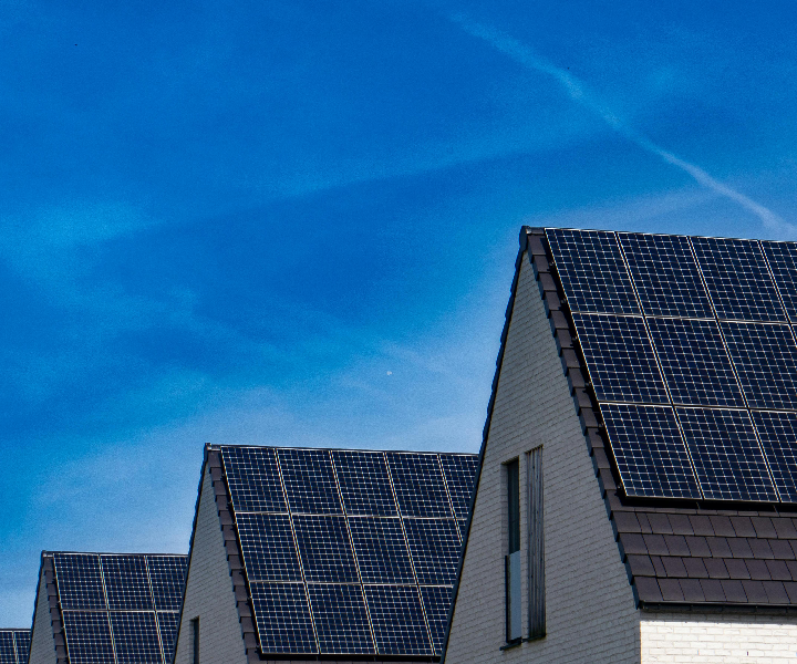 Houses with solar panels under blue sky.
