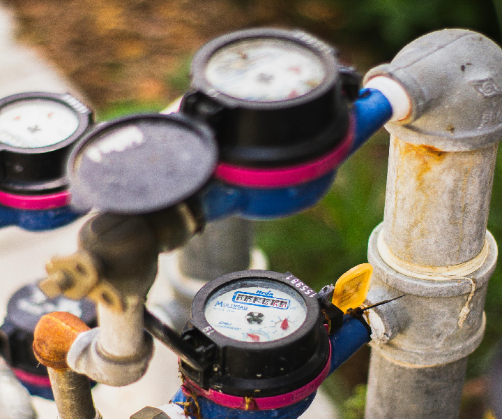 Water meters on outdoor pipes with gauges.