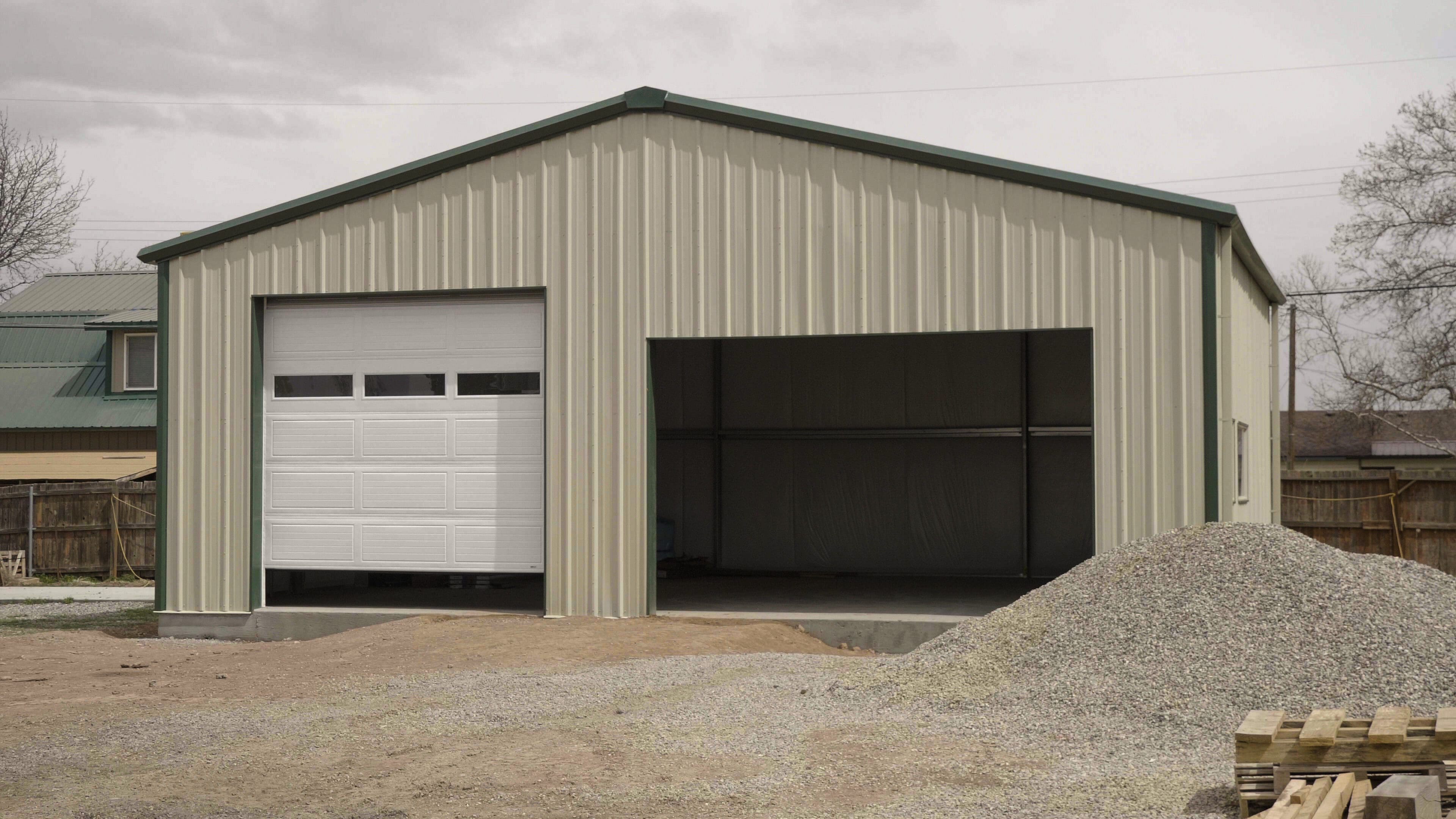 Metal building with garage door and gravel.