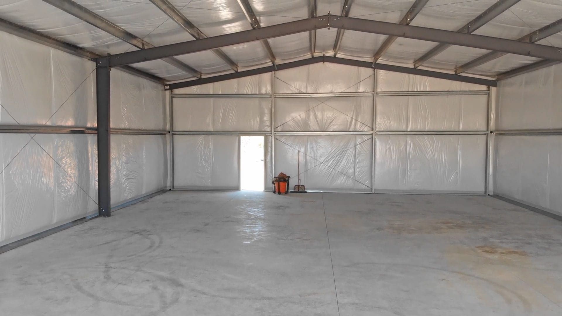 Empty metal warehouse with open door.