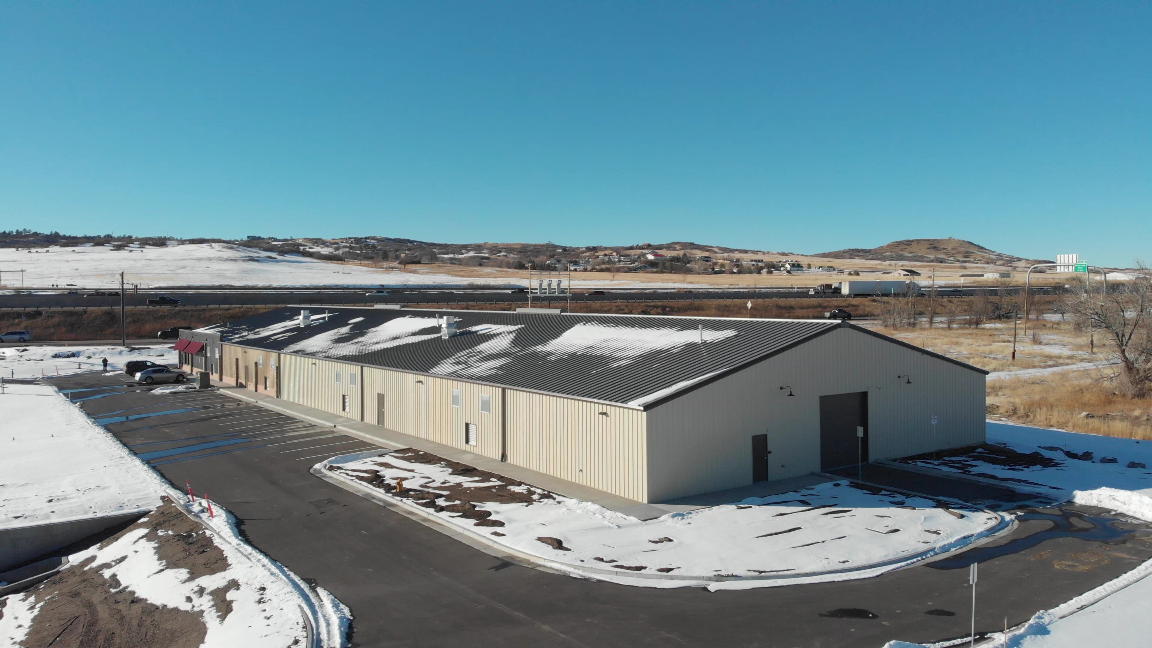 Industrial building surrounded by snowy landscape.