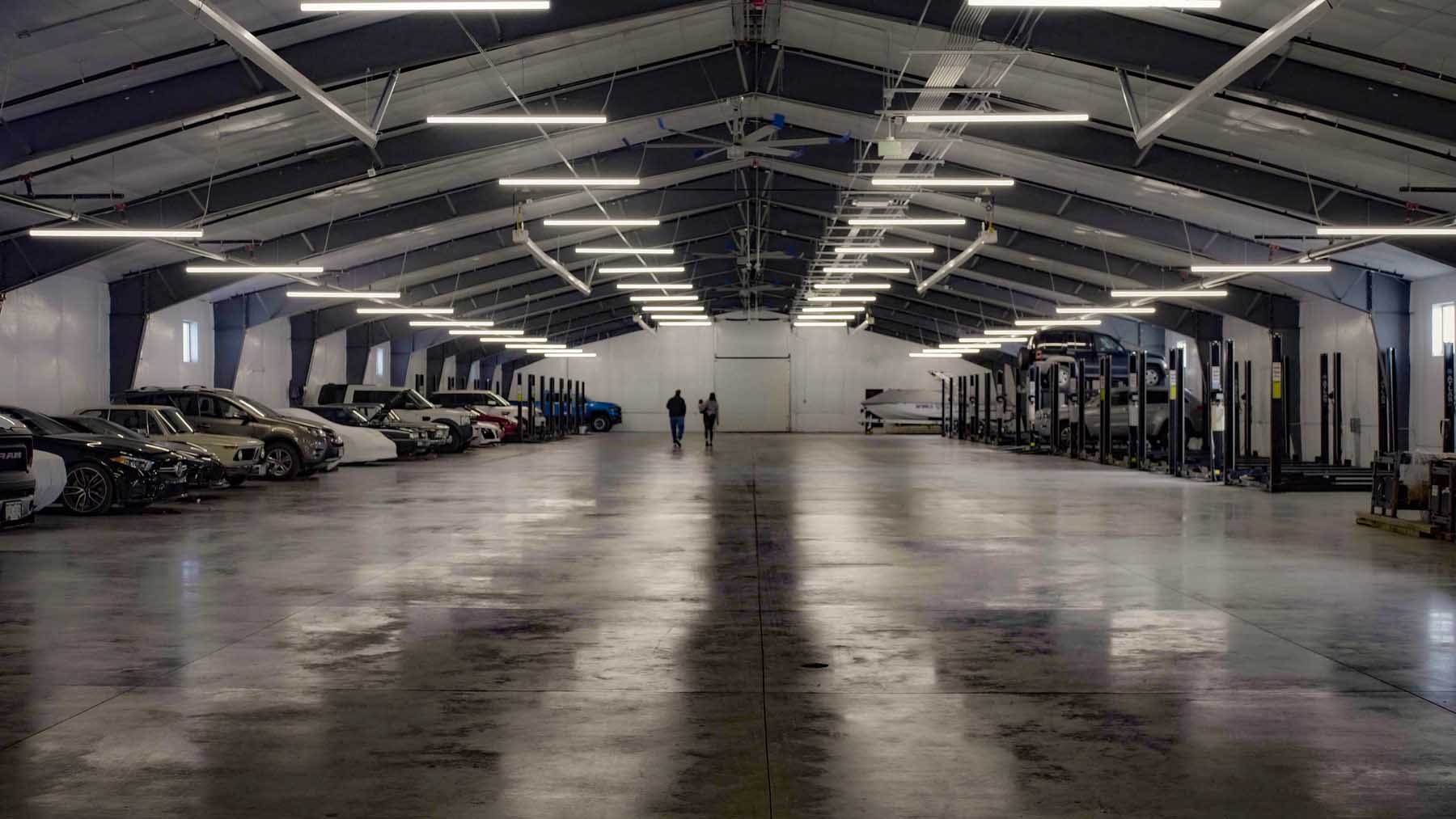 Large garage interior with parked cars.