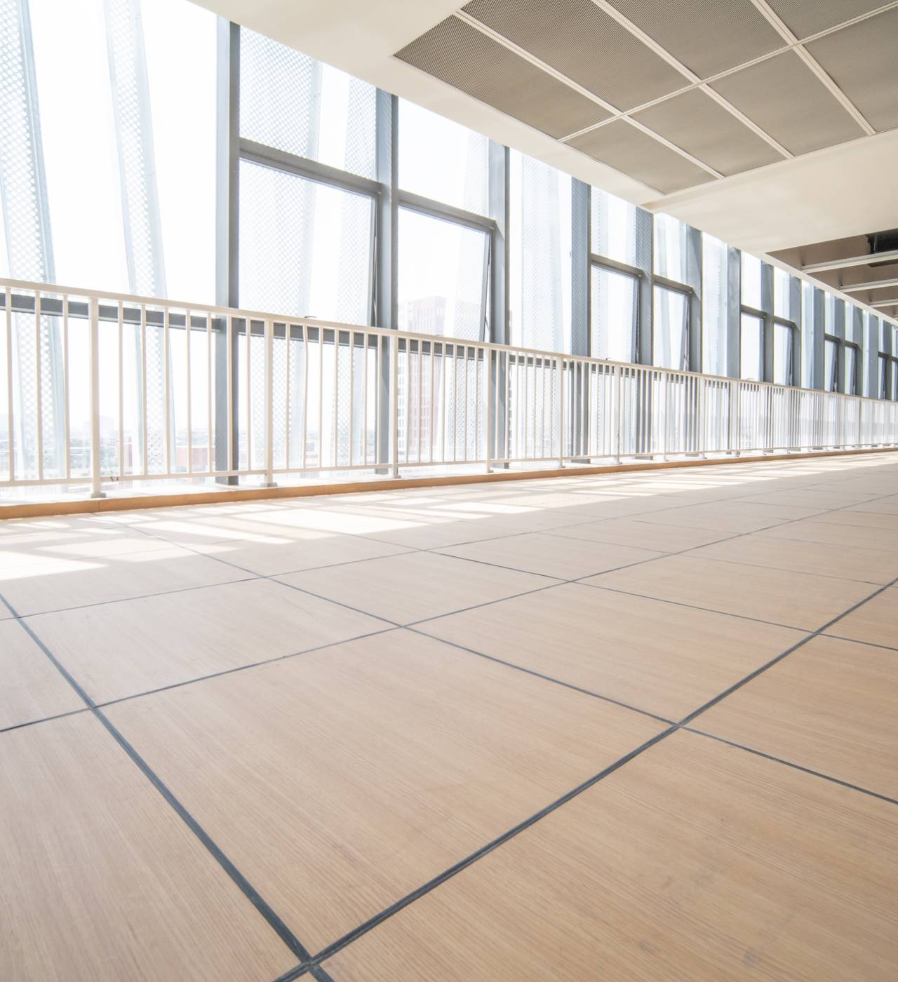 Sunlit corridor with large windows and flooring.