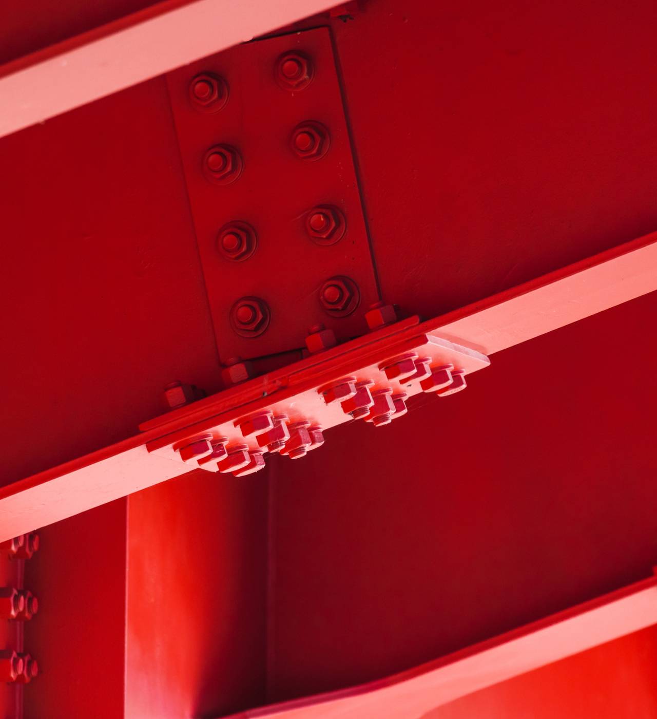 Red structural steel beams with bolts.