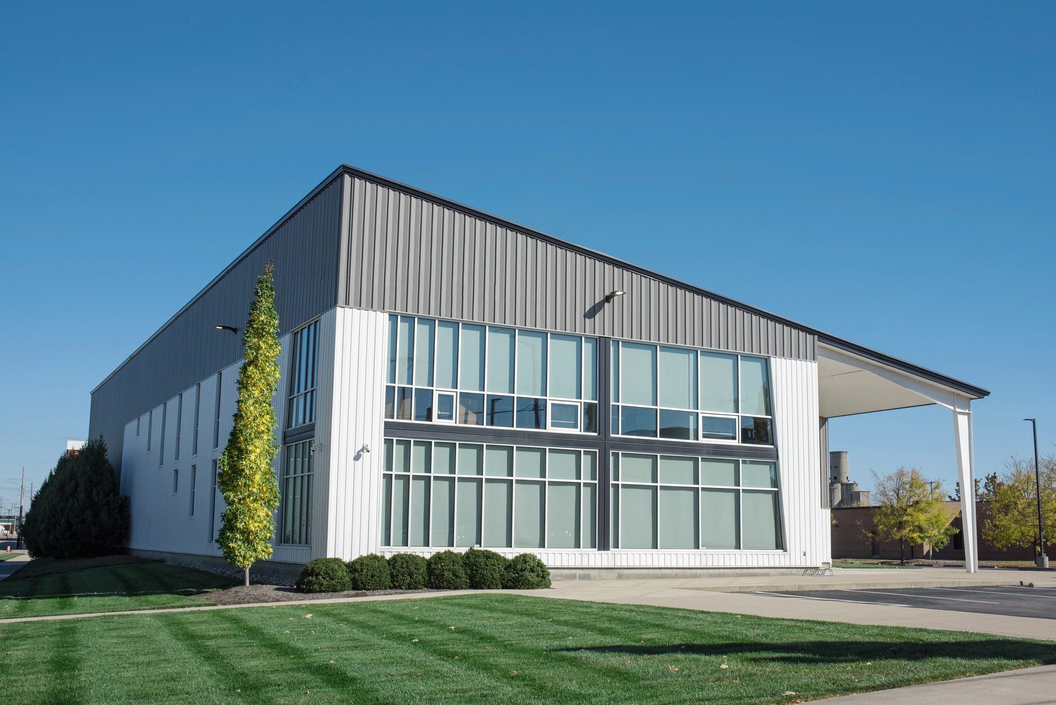 Modern building with large windows and lawn.
