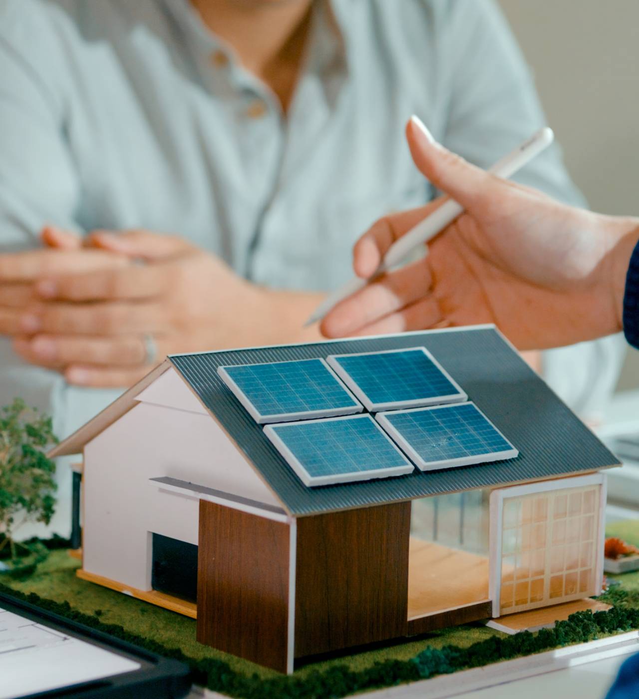 Model house with solar panels and people.