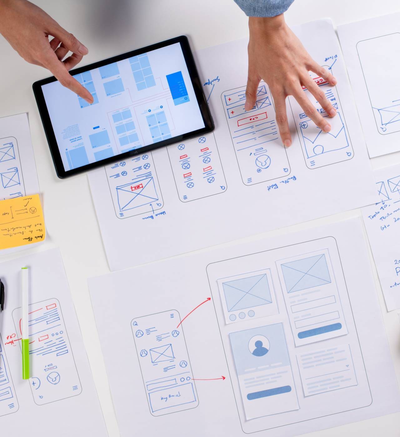 Tablet and papers with website design sketches.