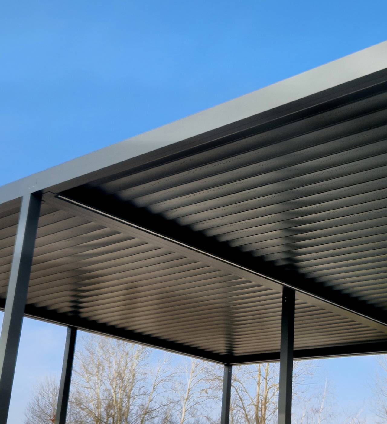 Modern metal roof under clear blue sky.