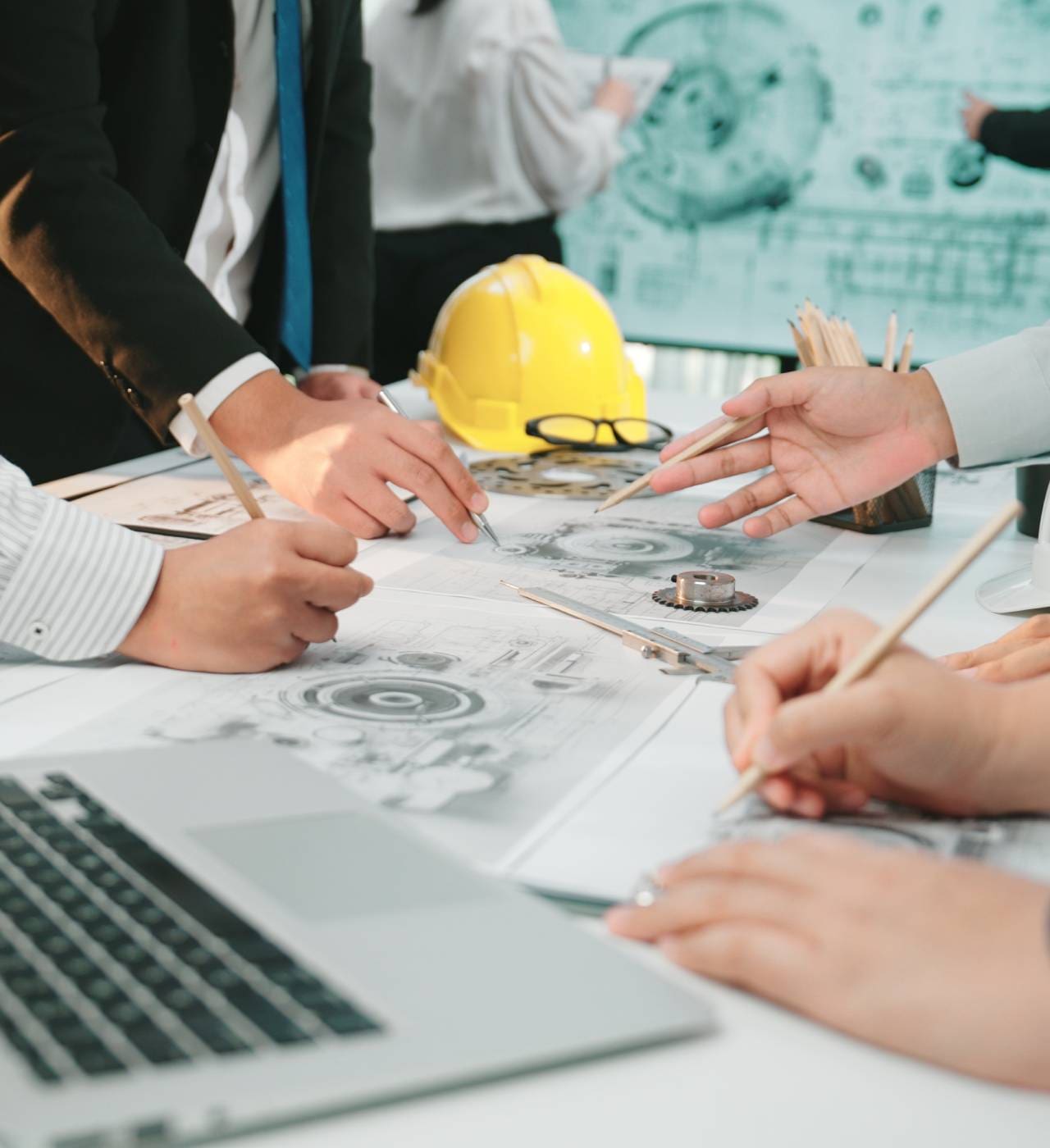 Engineers collaborate on technical blueprint plans.
