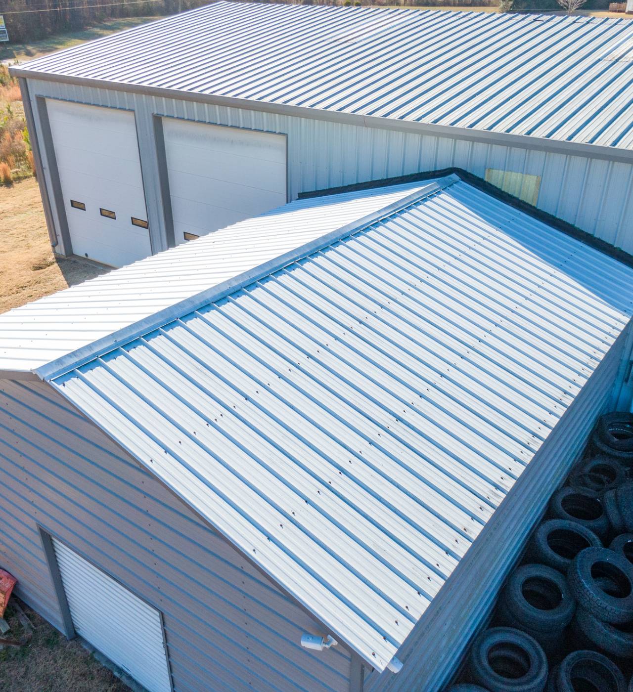 Metal-roofed building with stacked tires outside.