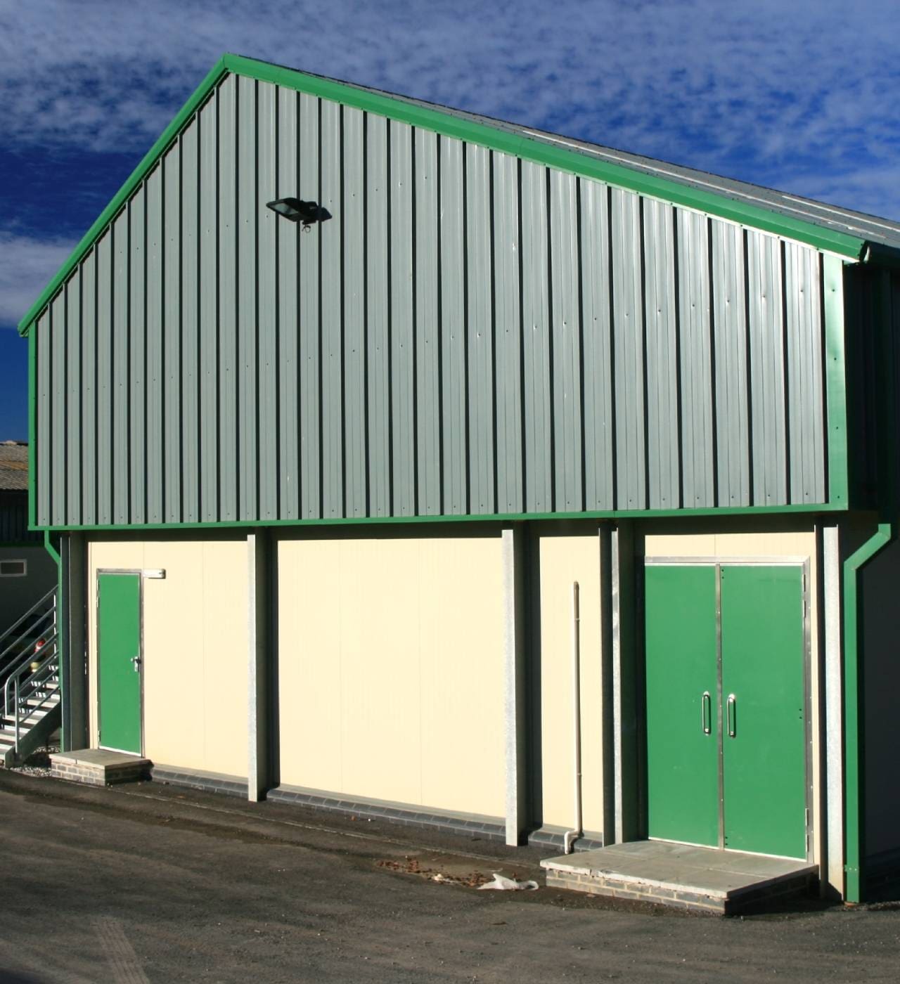 Industrial building with green and gray facade.