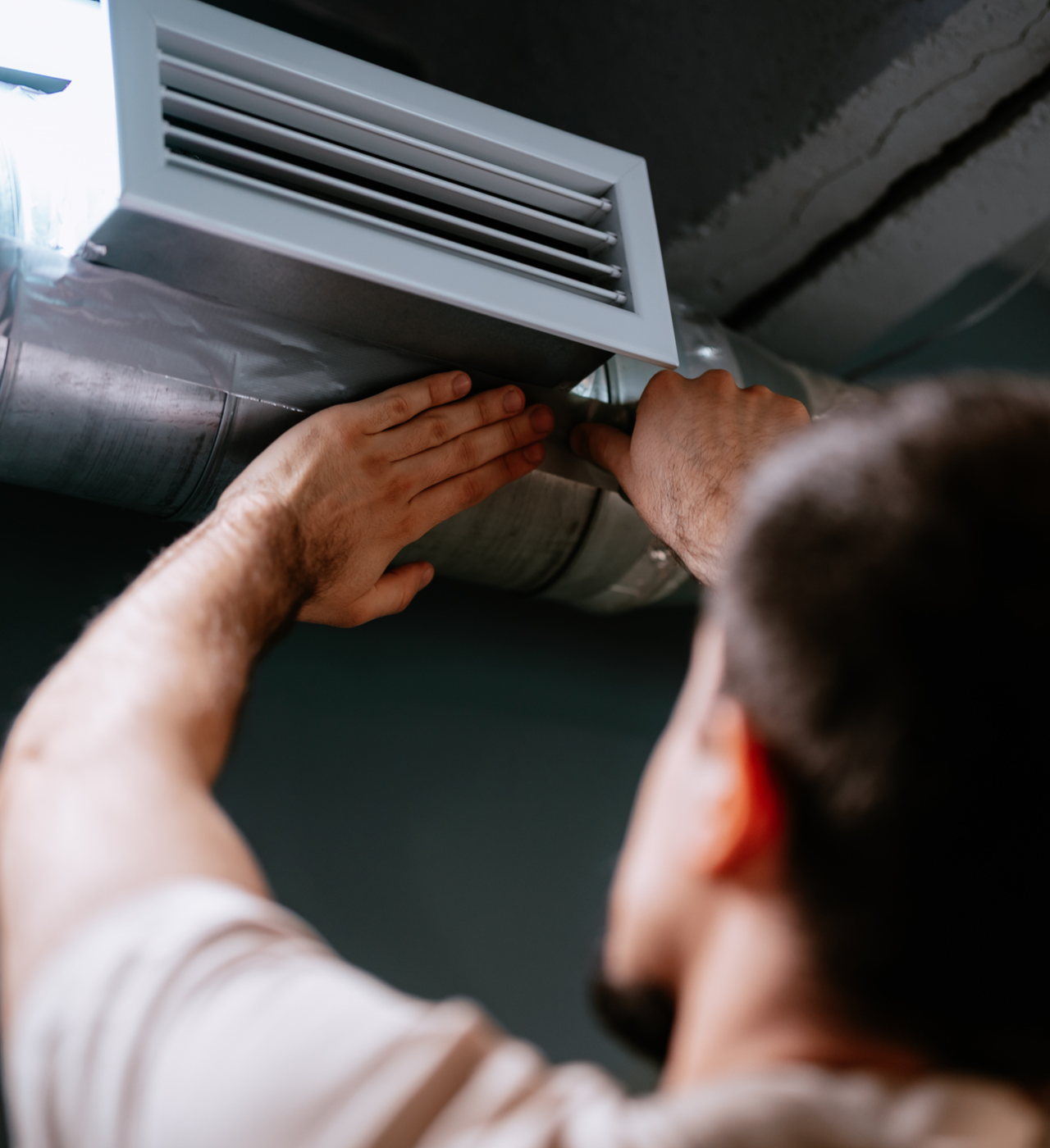 Person fixing air conditioning vent.