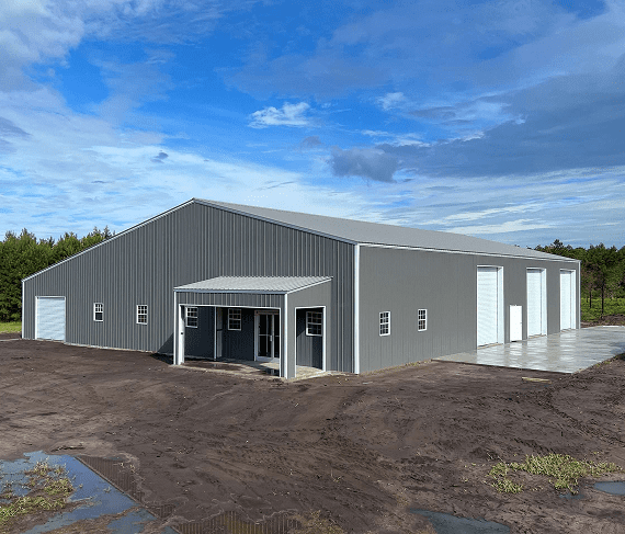 Gray metal building under blue cloudy sky.