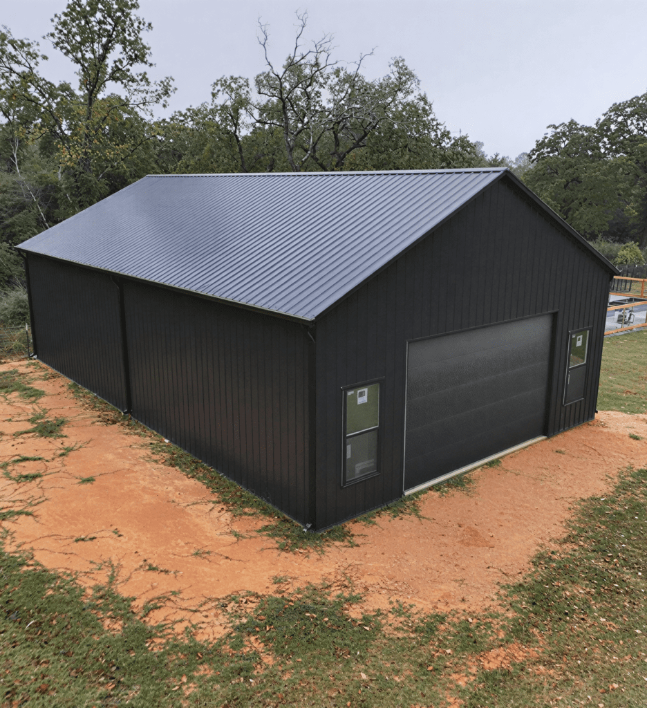 Black metal building with large garage door.