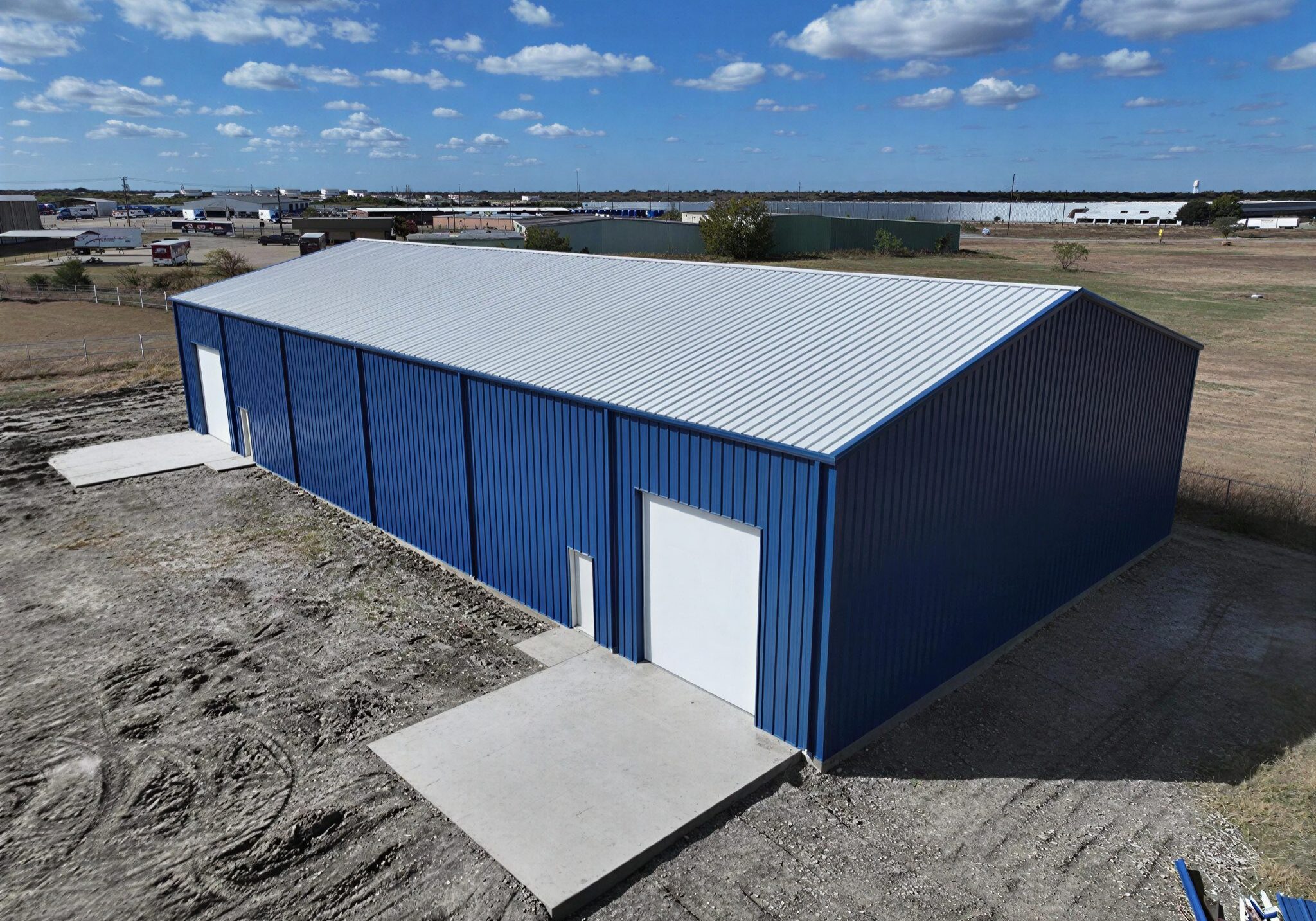 Blue metal building under a cloudy sky.
