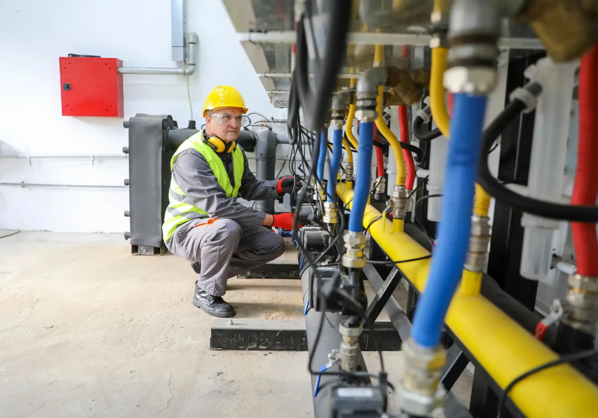 Technician checking industrial equipment and pipes.