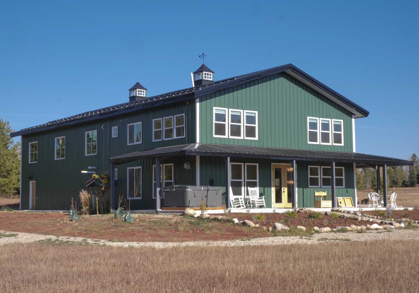 Green two-story house with front porch.