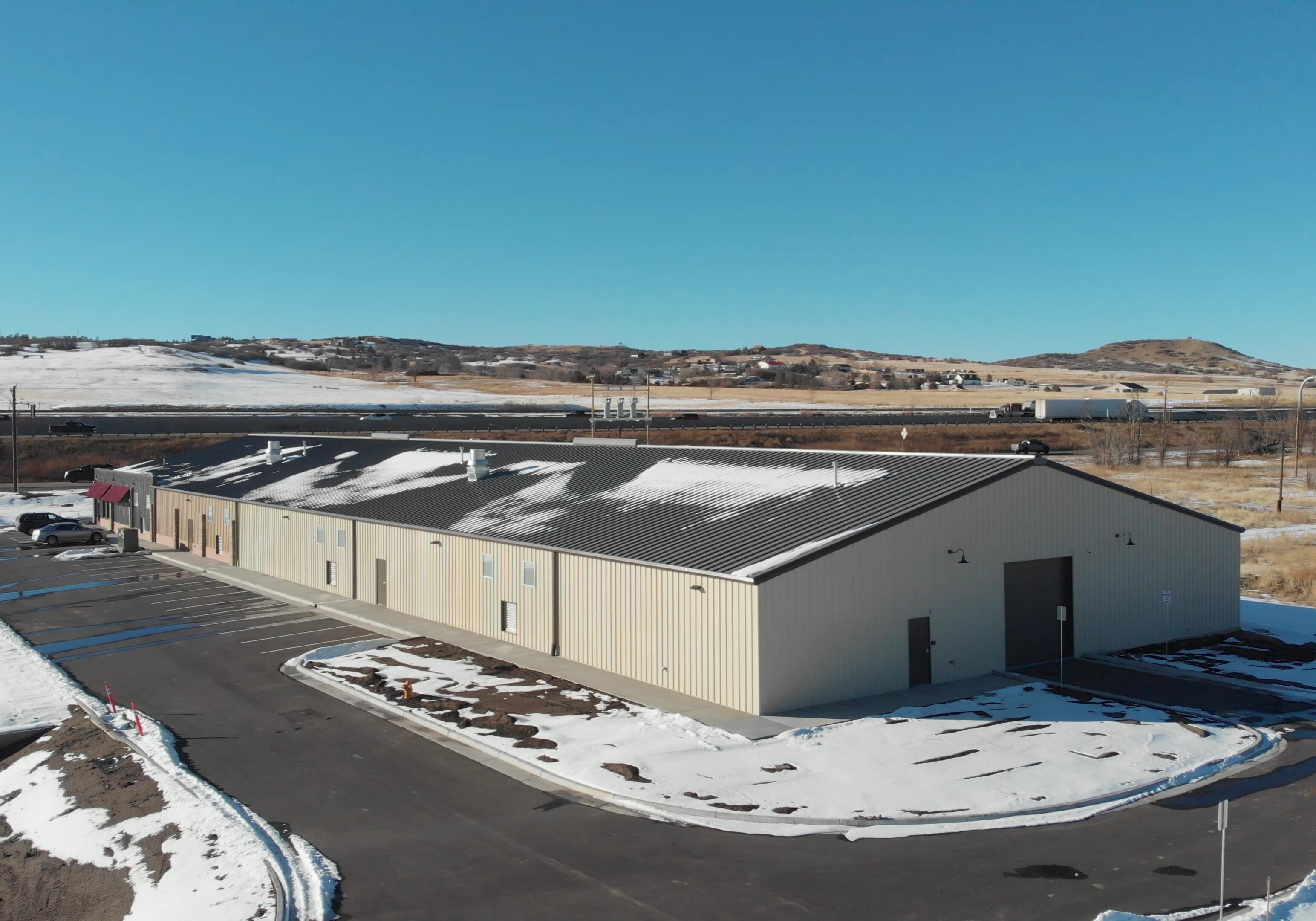 Industrial building surrounded by snowy landscape.