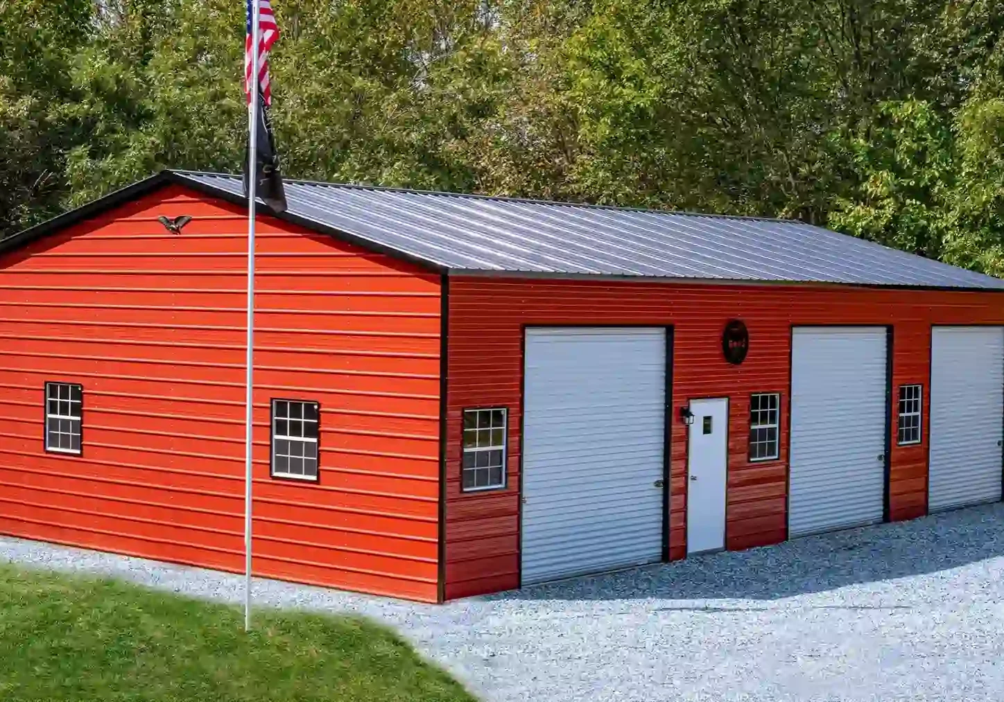 Red metal garage with three white doors.