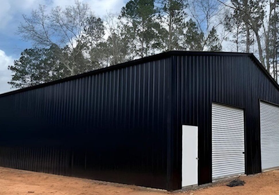 Large black metal building with roll-up doors.