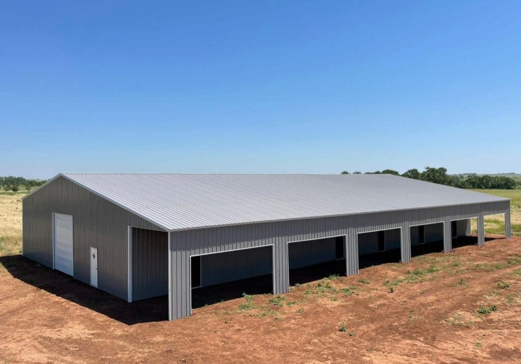 Large metal barn on open land.