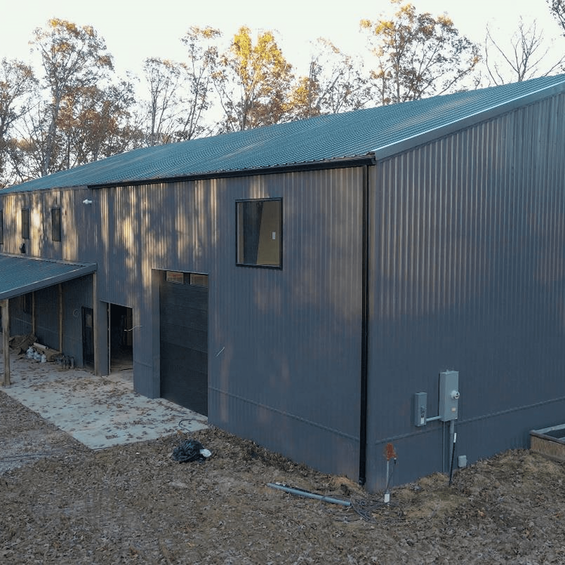 Gray industrial building surrounded by trees.