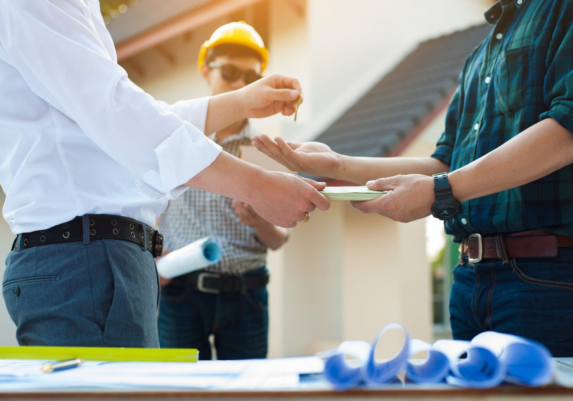 People exchanging keys and documents at construction.