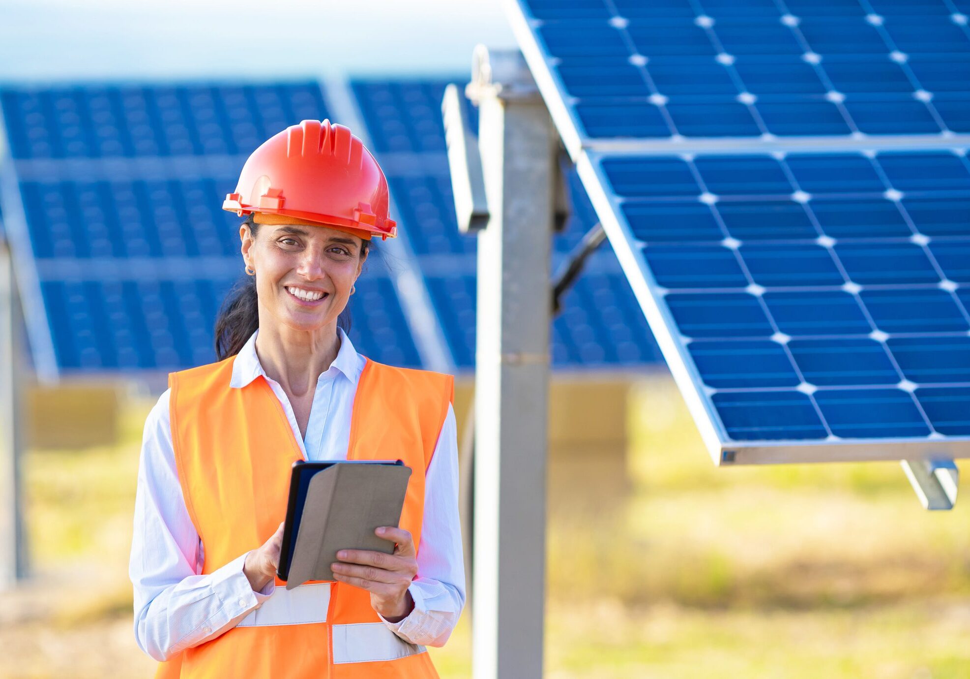 Engineer with tablet at solar panel field.