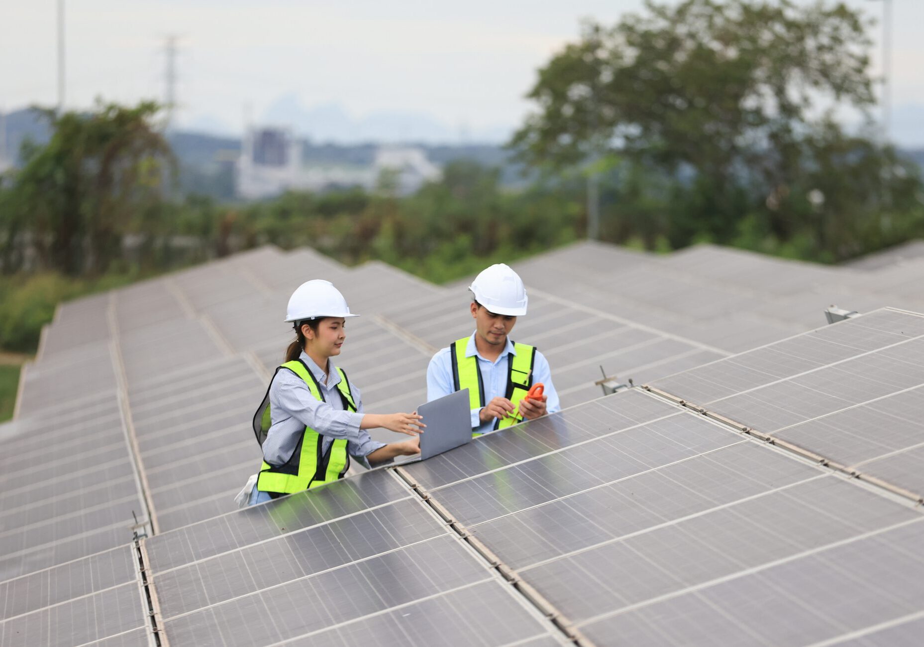 Workers inspecting solar panels with laptop.