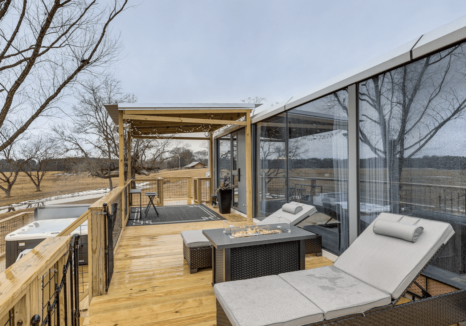 Outdoor deck with lounge chairs and trees.