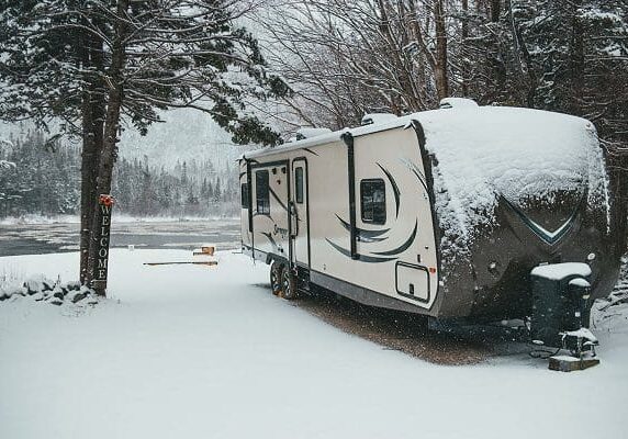RV parked by snowy lake