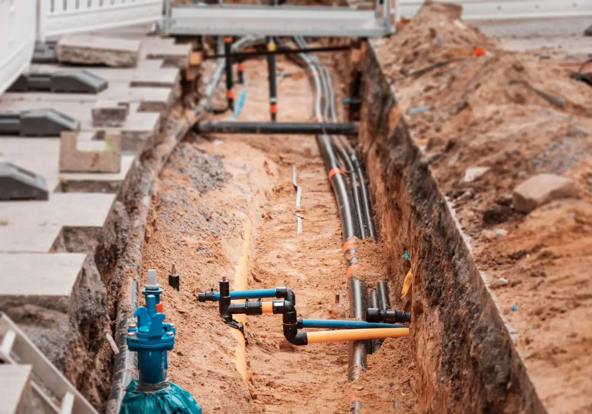 Trench with pipes and valves under construction.