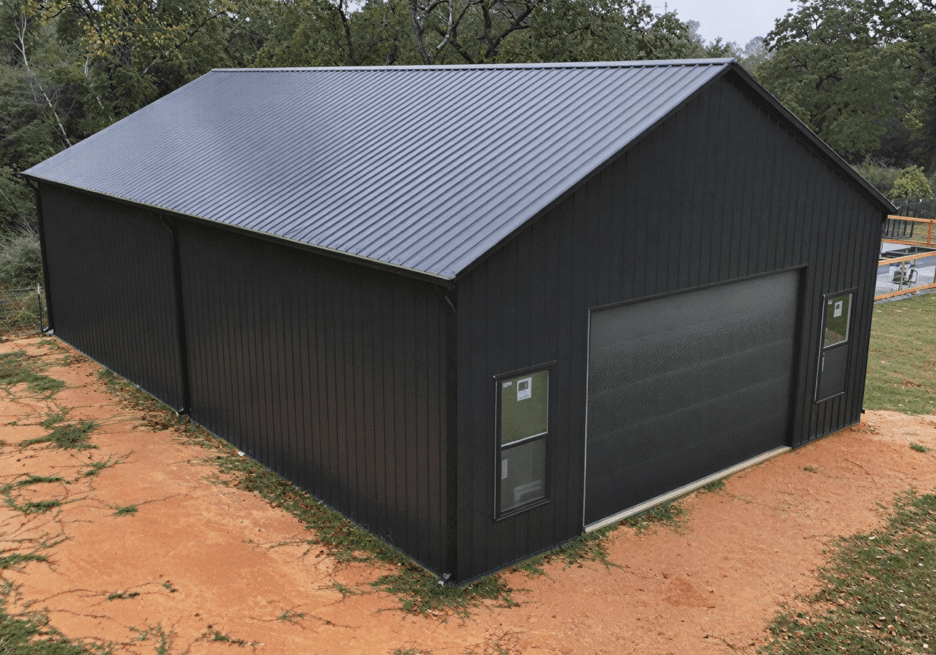 Black metal building with large garage door.